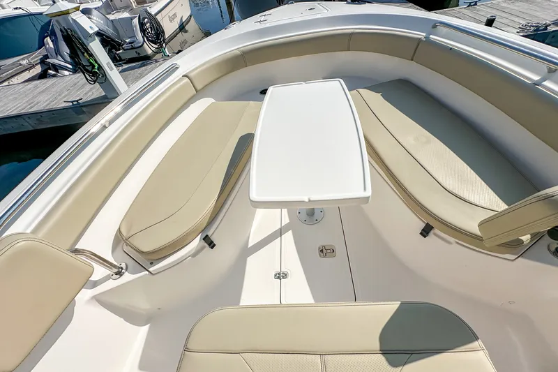 Slide: The Image of 2018 Pursuit C 260 Center Console boat interior with cushioned seating and table. - 38