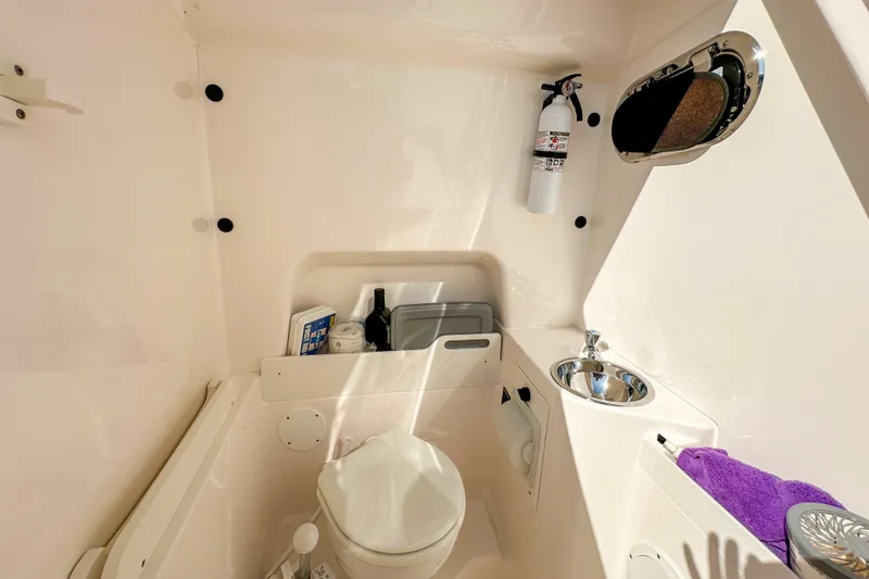Slide: The Image of Interior of 2018 Pursuit C 260 Center Console boat with toilet and sink. - 53