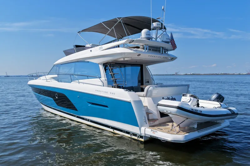 Slide: The Image of 2023 Prestige 590 yacht on calm water, featuring sleek design and luxury amenities. - 10