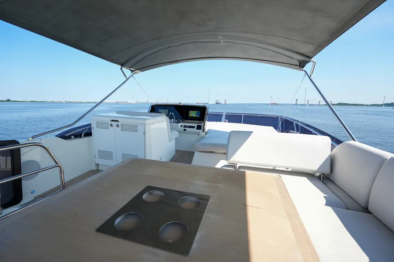 Slide: The Image of Luxurious 2023 Prestige 590 yacht deck with seating and navigation controls, overlooking calm waters. - 30