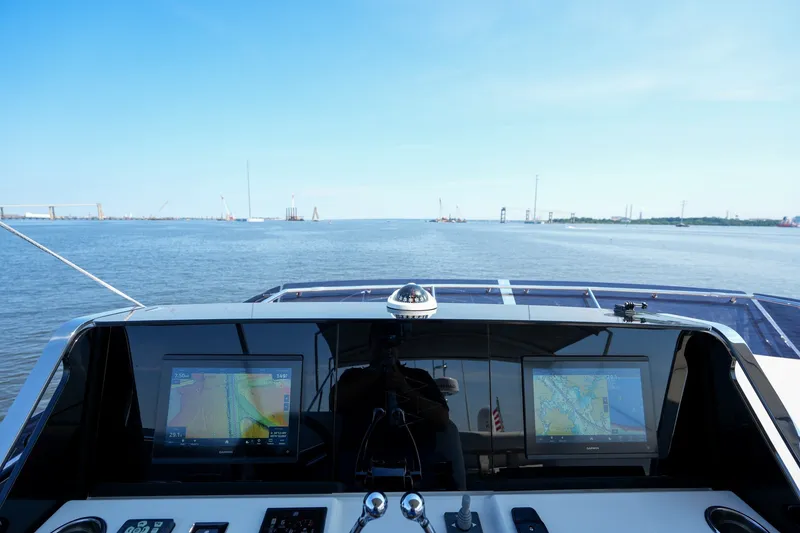 Slide: The Image of Cockpit view of 2023 Prestige 590 yacht with navigation screens on open water. - 38