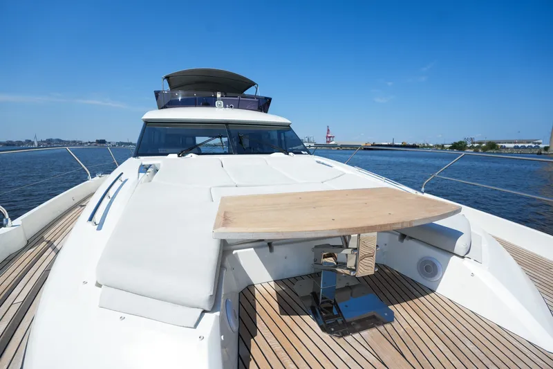Slide: The Image of Luxurious 2023 Prestige 590 yacht deck with seating and table, cruising on a sunny day. - 47