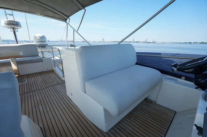 Slide: The Image of Luxurious 2023 Prestige 590 yacht interior with seating and Garmin equipment, overlooking serene waters. - 36