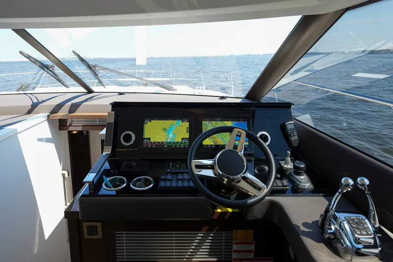 Slide: The Image of Cockpit of 2023 Prestige 590 yacht with navigation system and steering wheel, overlooking the ocean. - 69