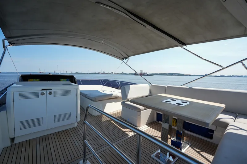 Slide: The Image of Luxurious 2023 Prestige 590 yacht deck with seating and table, overlooking serene waters. - 28