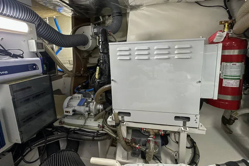 Slide: The Image of Engine room of 2023 Prestige 590 yacht with machinery and fire extinguisher. - 103