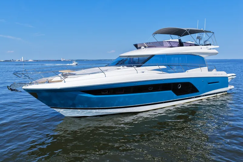 Slide: The Image of Luxury 2023 Prestige 590 yacht on calm blue waters under clear sky. - 9