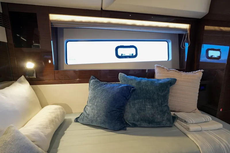 Slide: The Image of Luxurious interior of 2023 Prestige 590 yacht with plush cushions and elegant window view. - 86