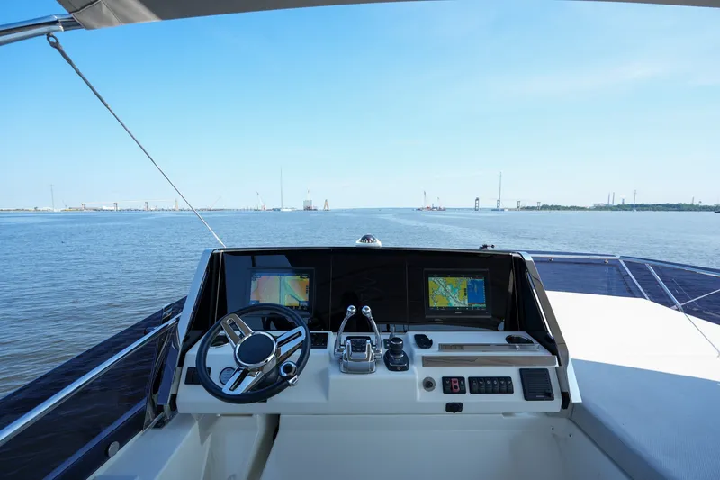 Slide: The Image of Cockpit view of 2023 Prestige 590 yacht with navigation screens and steering wheel. - 37