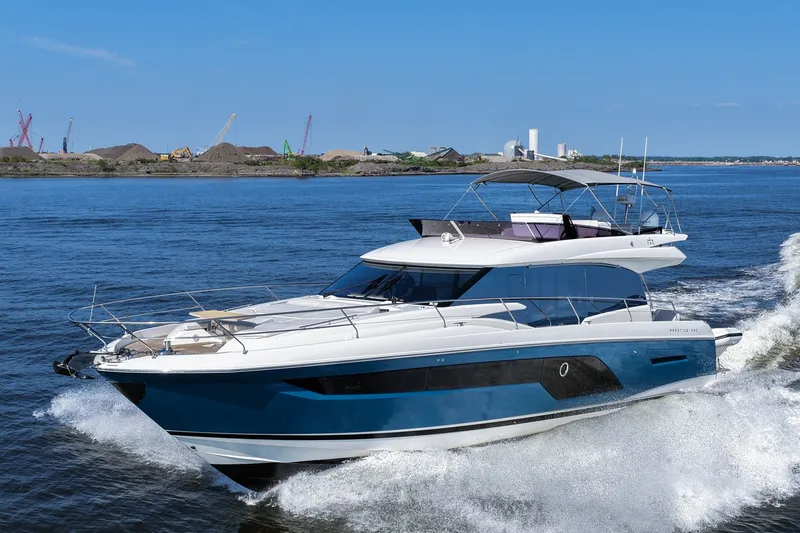 Slide: The Image of Luxury 2023 Prestige 590 yacht cruising on open water, showcasing sleek design and elegance. - 16