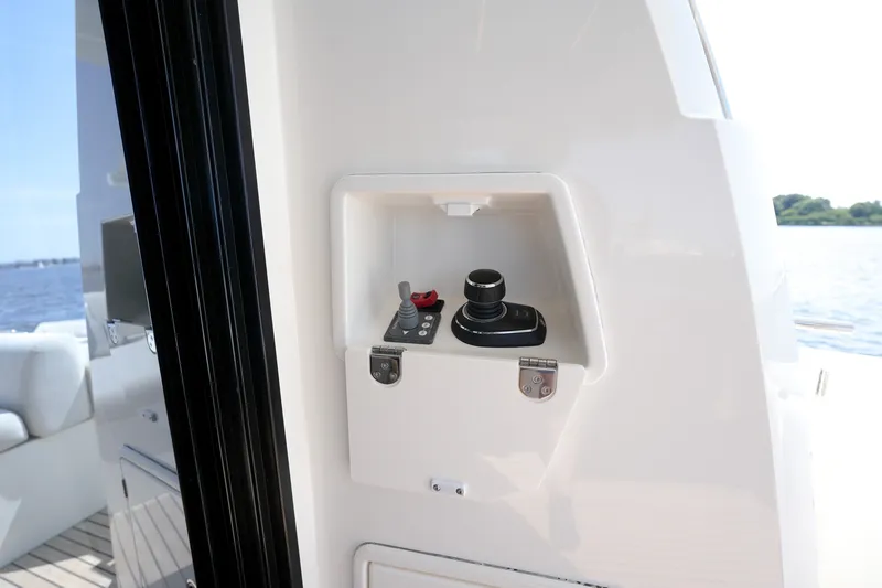 Slide: The Image of Control panel on a 2023 Prestige 590 yacht, featuring joystick and switches. - 24