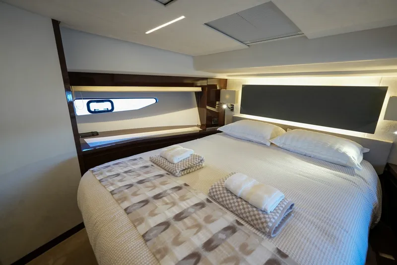 Slide: The Image of Luxurious bedroom interior of 2023 Prestige 590 yacht with modern design and cozy bedding. - 77