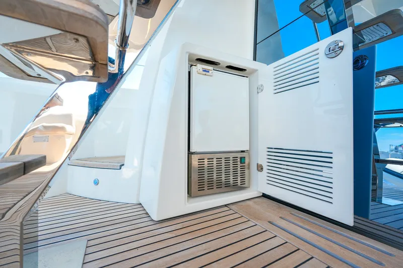 Slide: The Image of Luxury yacht Prestige 590, 2023 model, featuring sleek deck design and built-in storage. - 26