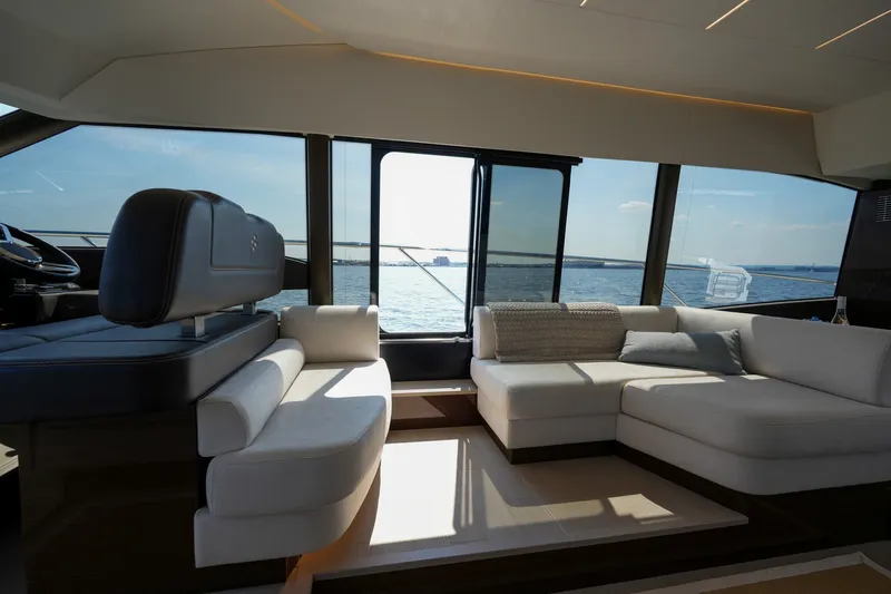 Slide: The Image of Luxurious interior of 2023 Prestige 590 yacht with ocean view through large windows. - 65