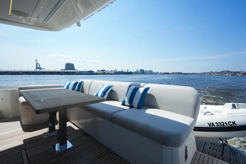 Slide: The Image of Luxurious 2023 Prestige 590 yacht deck with seating, table, and scenic waterfront view. - 19