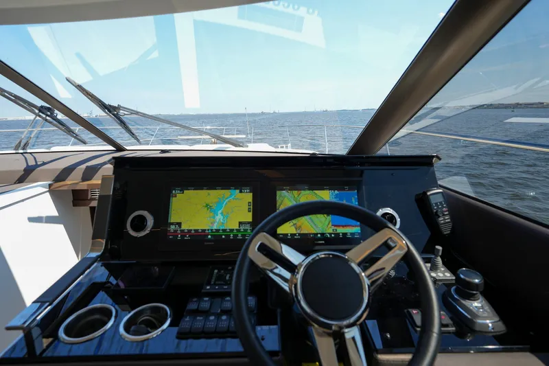 Slide: The Image of Cockpit view of 2023 Prestige 590 yacht with navigation screens and steering wheel. - 70