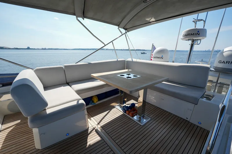 Slide: The Image of Luxurious 2023 Prestige 590 yacht deck with seating and table, overlooking serene ocean view. - 29