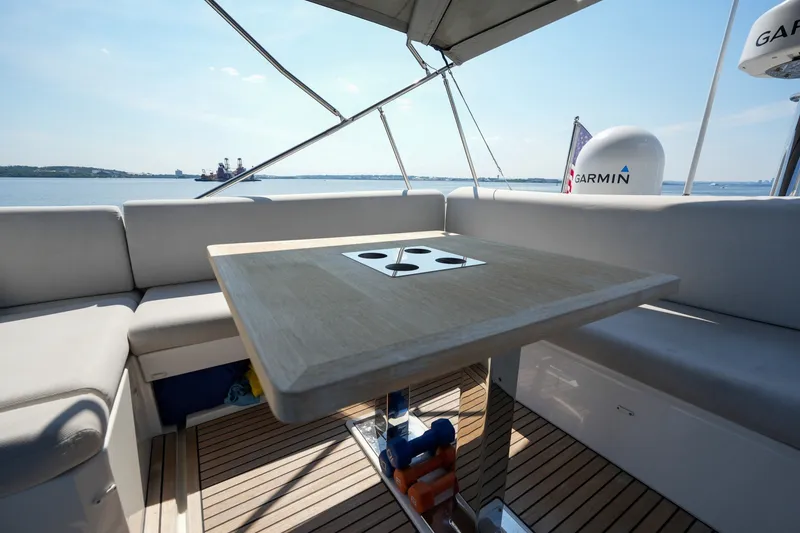 Slide: The Image of Luxurious 2023 Prestige 590 yacht deck with seating and table, overlooking serene waters. - 31