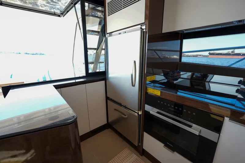 Slide: The Image of Modern kitchen interior on 2023 Prestige 590 yacht with stainless steel appliances and ocean view. - 58