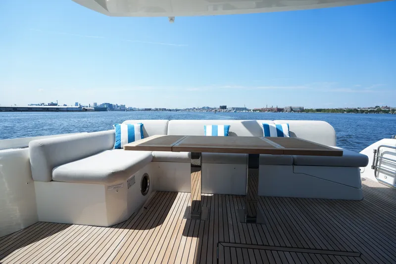 Slide: The Image of Luxurious 2023 Prestige 590 yacht deck with seating and table, overlooking serene waters. - 21