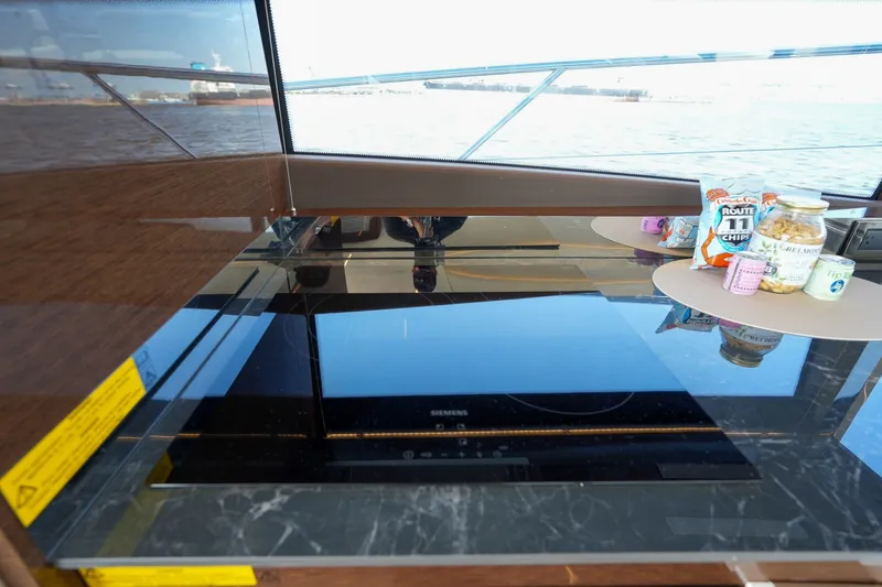 Slide: The Image of Modern kitchen area on 2023 Prestige 590 yacht with snacks and scenic ocean view. - 56