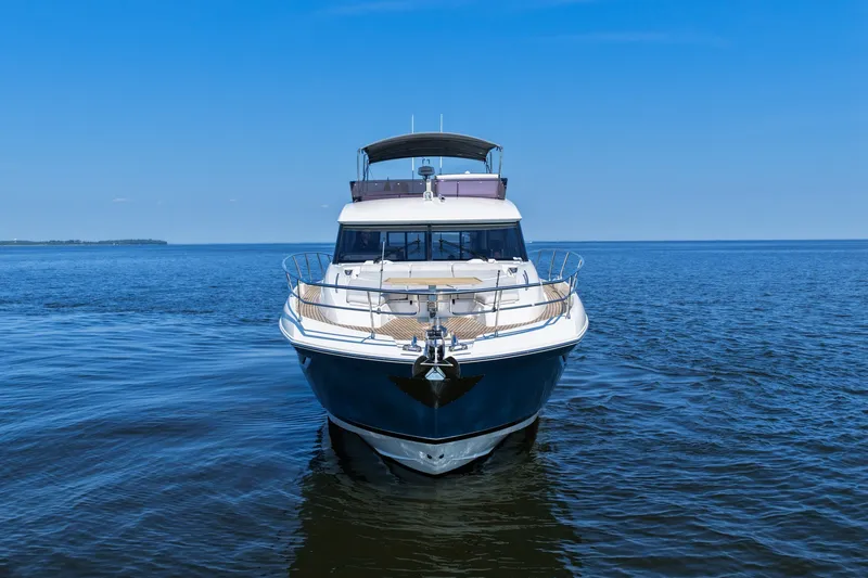 Slide: The Image of Front view of a 2023 Prestige 590 yacht on calm blue waters. - 8