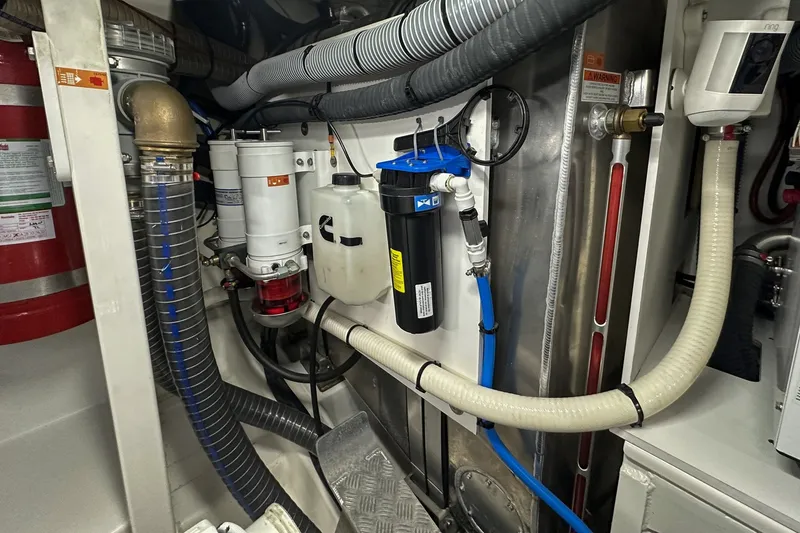 Slide: The Image of Engine room of a 2023 Prestige 590 yacht, showcasing various mechanical components and systems. - 104