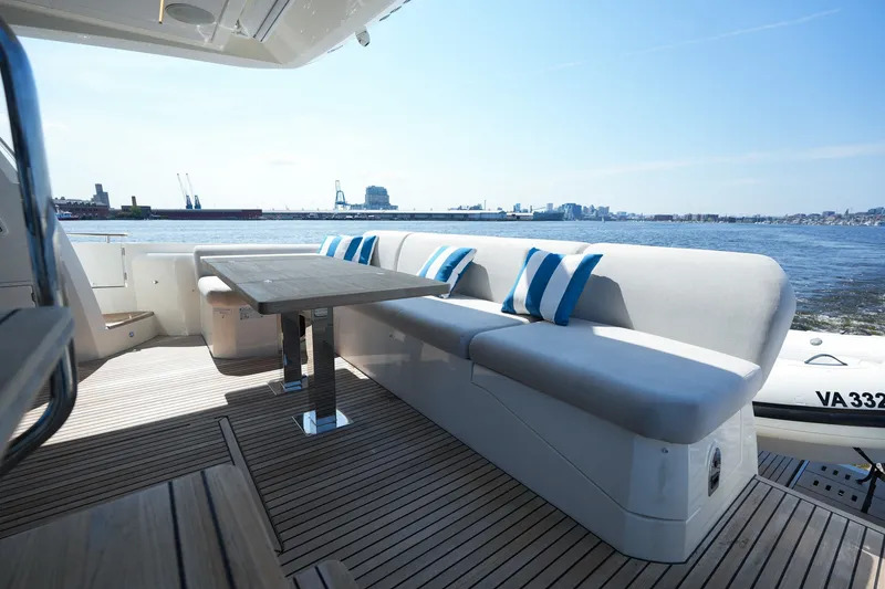 Slide: The Image of Luxurious 2023 Prestige 590 yacht deck with seating, table, and ocean view. - 20