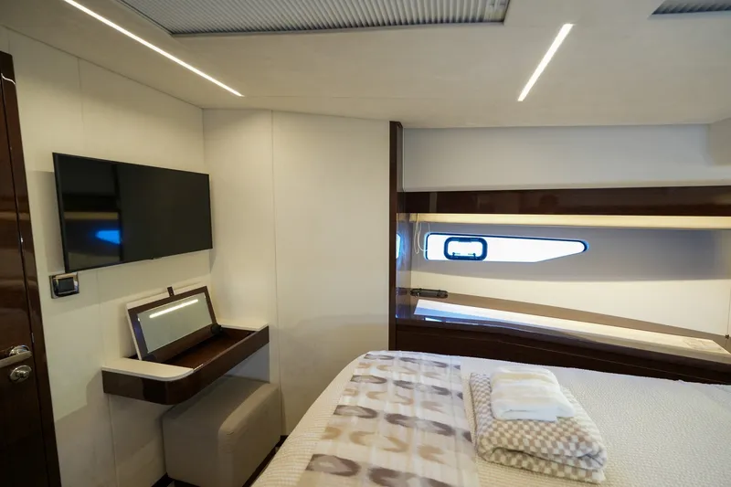 Slide: The Image of Luxurious 2023 Prestige 590 yacht interior with modern bedroom, TV, and window view. - 78