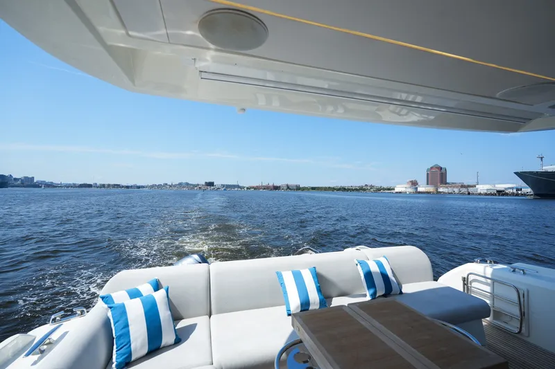 Slide: The Image of Luxurious 2023 Prestige 590 yacht cruising with scenic waterfront view and stylish seating. - 22