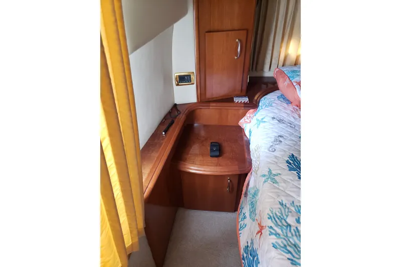 Slide: The Image of Interior of 2005 Carver 444 Cockpit Motor Yacht with wooden cabinetry and colorful bedding. - 9