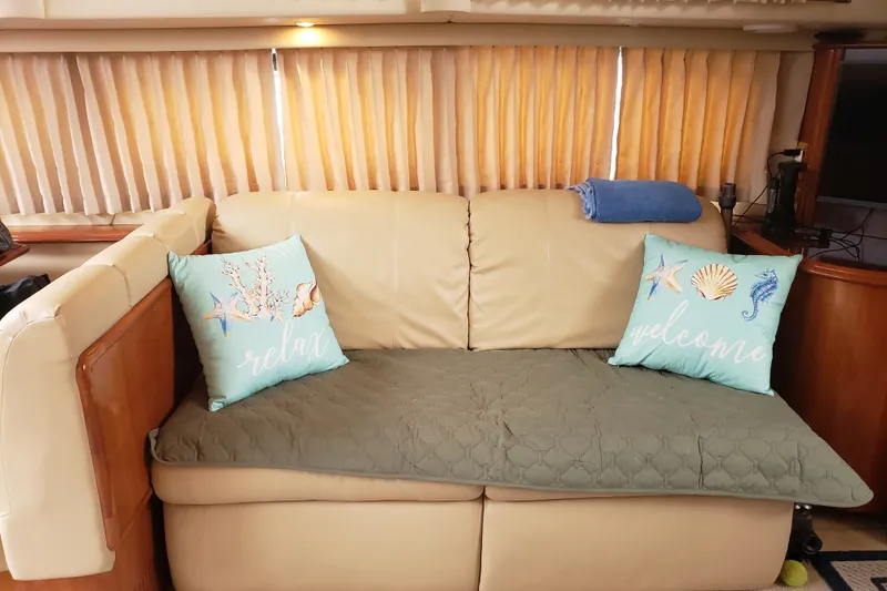 Slide: The Image of Interior of 2005 Carver 444 Cockpit Motor Yacht with cozy beige sofa and decorative pillows. - 5