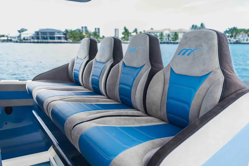 Slide: The Image of Luxury seating on 2026 Midnight Express 52 Vitesse boat, featuring blue and gray upholstery. - 26