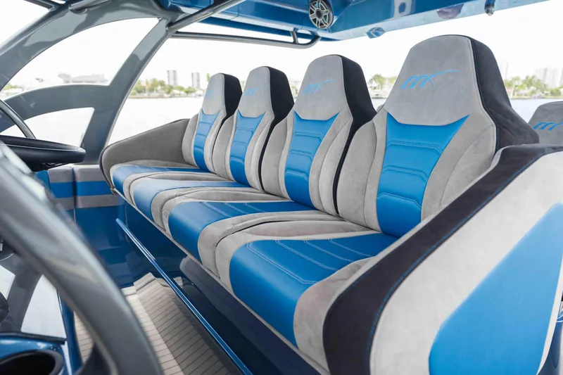 Slide: The Image of Luxurious seating inside the 2026 Midnight Express 52 Vitesse boat, featuring blue and gray upholstery. - 29