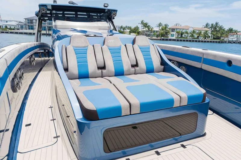 Slide: The Image of 2026 Midnight Express 52 Vitesse luxury yacht with blue and gray seating, docked by waterfront homes. - 17