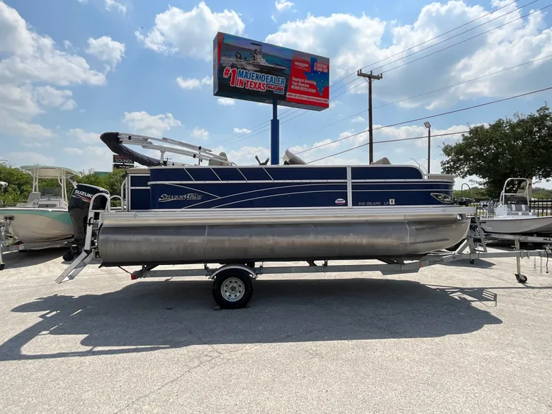Slide: The Image of A 2016 SilverWave 210L pontoon boat on a trailer under a sunny sky. - 2