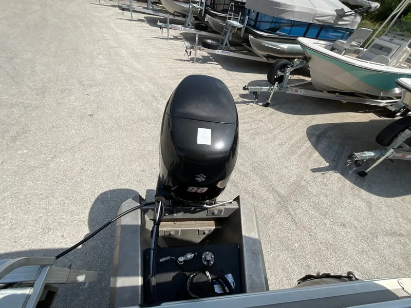 Slide: The Image of A Suzuki 90 HP outboard motor is mounted on a 2016 SilverWave 210L, surrounded by other boats on trailers. - 13