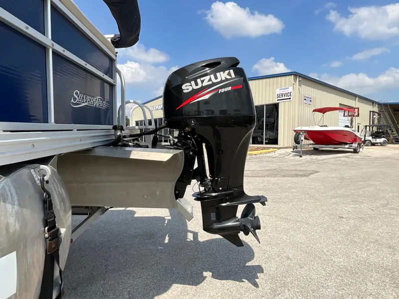 Slide: The Image of A 2016 SilverWave 210L with a Suzuki outboard motor. It is parked in front of a building. - 5