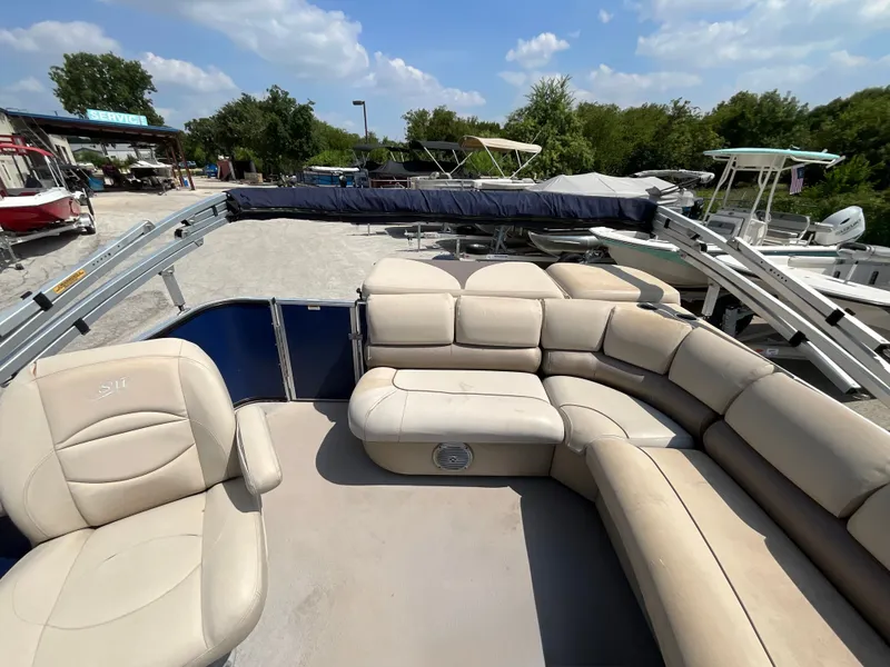 Slide: The Image of The image shows the spacious, beige-upholstered seating area of a 2016 SilverWave 210L pontoon boat. - 7