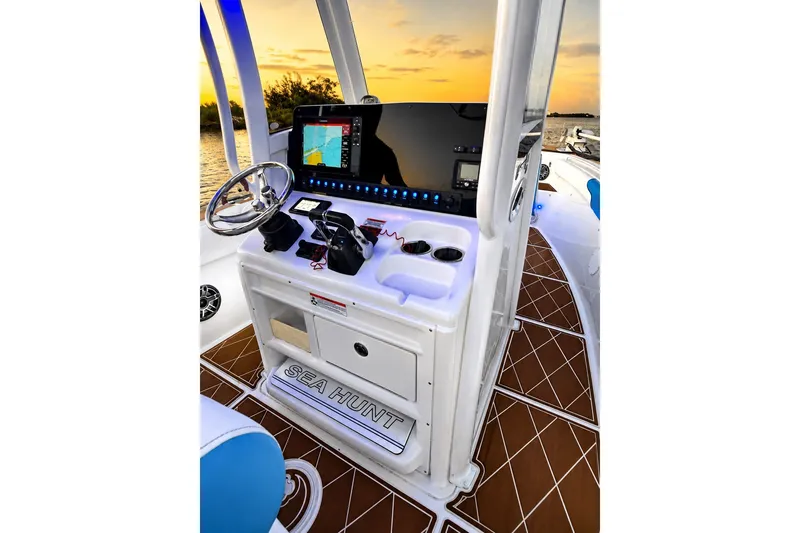 Slide: The Image of 2018 Sea Hunt Gamefish 27 Coffin Box helm with modern controls at sunset. - 28