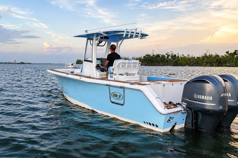 Slide: The Image of 2018 Sea Hunt Gamefish 27 Coffin Box boat on water, featuring dual Yamaha engines. - 16