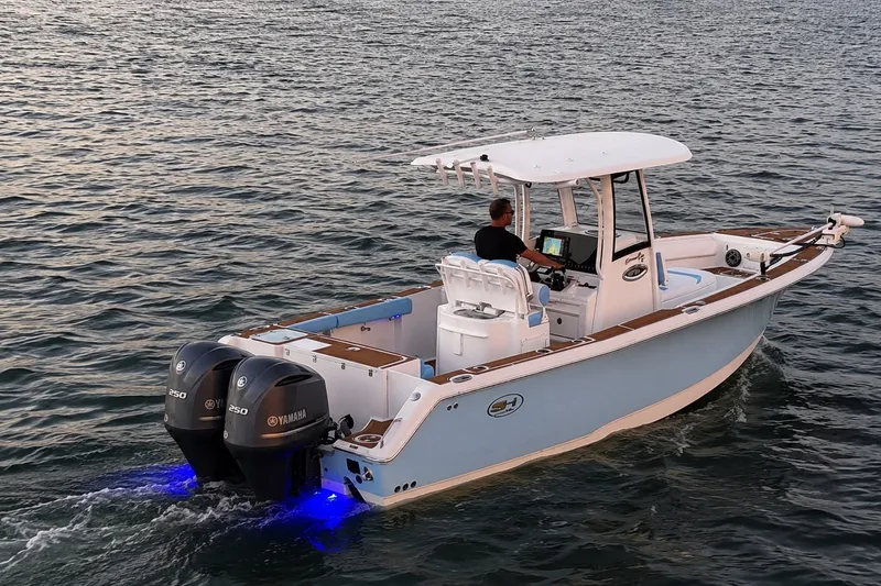 Slide: The Image of 2018 Sea Hunt Gamefish 27 Coffin Box boat cruising on water with dual Yamaha engines. - 6