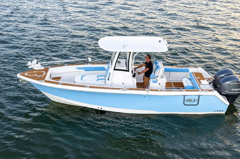 Slide: The Image of 2018 Sea Hunt Gamefish 27 Coffin Box boat on water, featuring dual Yamaha engines. - 18