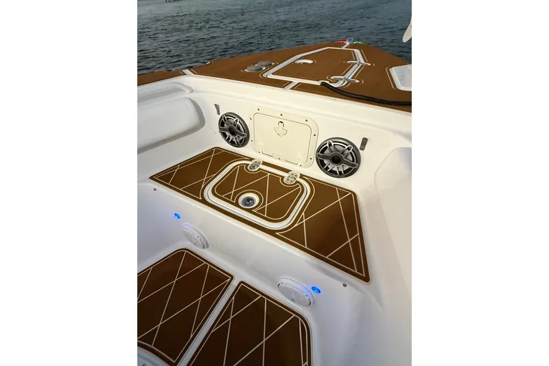 Slide: The Image of 2018 Sea Hunt Gamefish 27 Coffin Box boat interior with speakers and brown deck. - 21