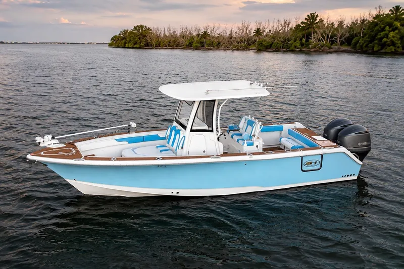 Slide: The Image of 2018 Sea Hunt Gamefish 27 Coffin Box boat on calm water, featuring dual Yamaha engines. - 4