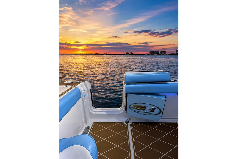 Slide: The Image of 2018 Sea Hunt Gamefish 27 boat at sunset, featuring blue seating and ocean view. - 25