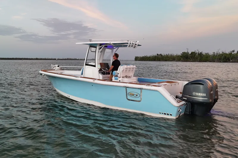 Slide: The Image of 2018 Sea Hunt Gamefish 27 Coffin Box boat on calm water at sunset. - 13