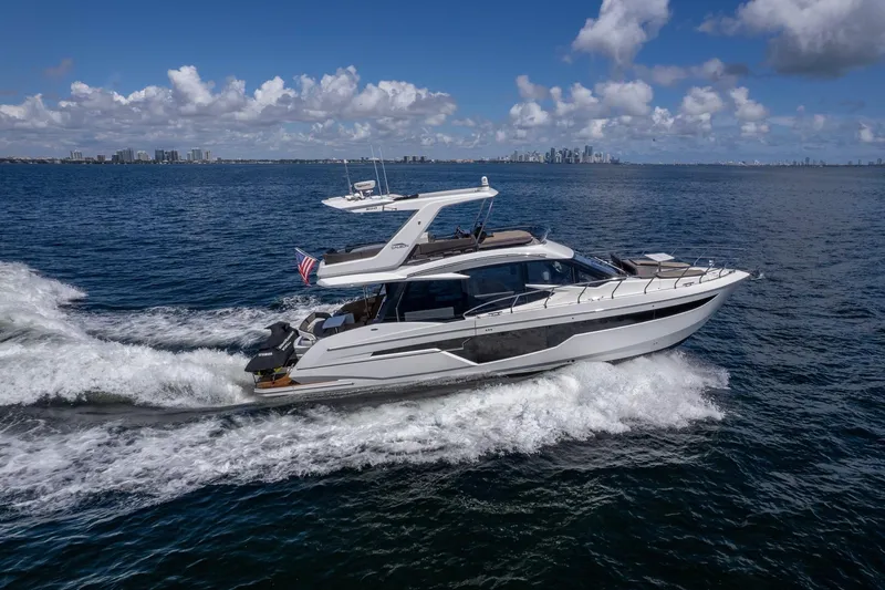 Slide: The Image of 2021 Galeon 500 Fly yacht cruising on open water under a clear blue sky. - 1