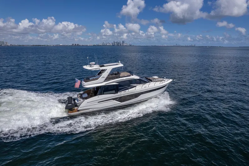 Slide: The Image of 2021 Galeon 500 Fly yacht cruising on open water under a clear blue sky. - 2