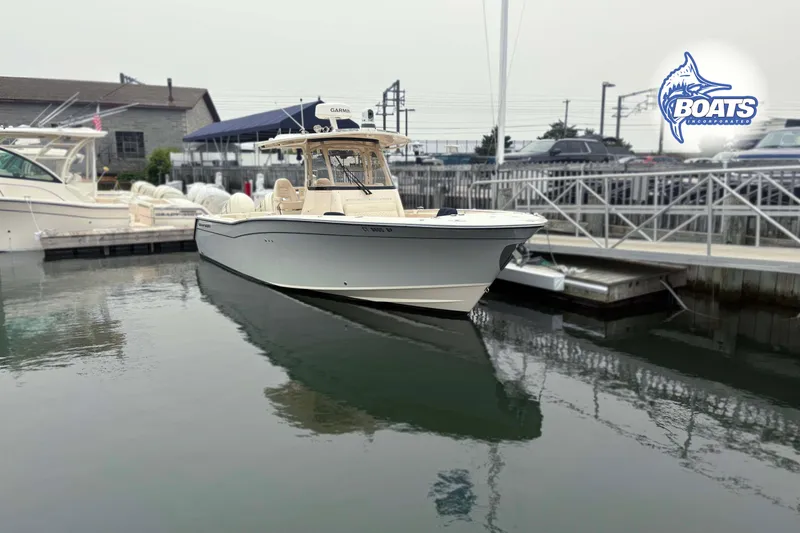 Slide: The Image of 2024 Grady-White Canyon 306 boat docked at marina, showcasing sleek design and modern features. - 2